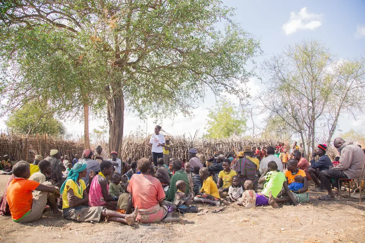 A congregation gathered for Bible teaching under a tree in rural South Sudan